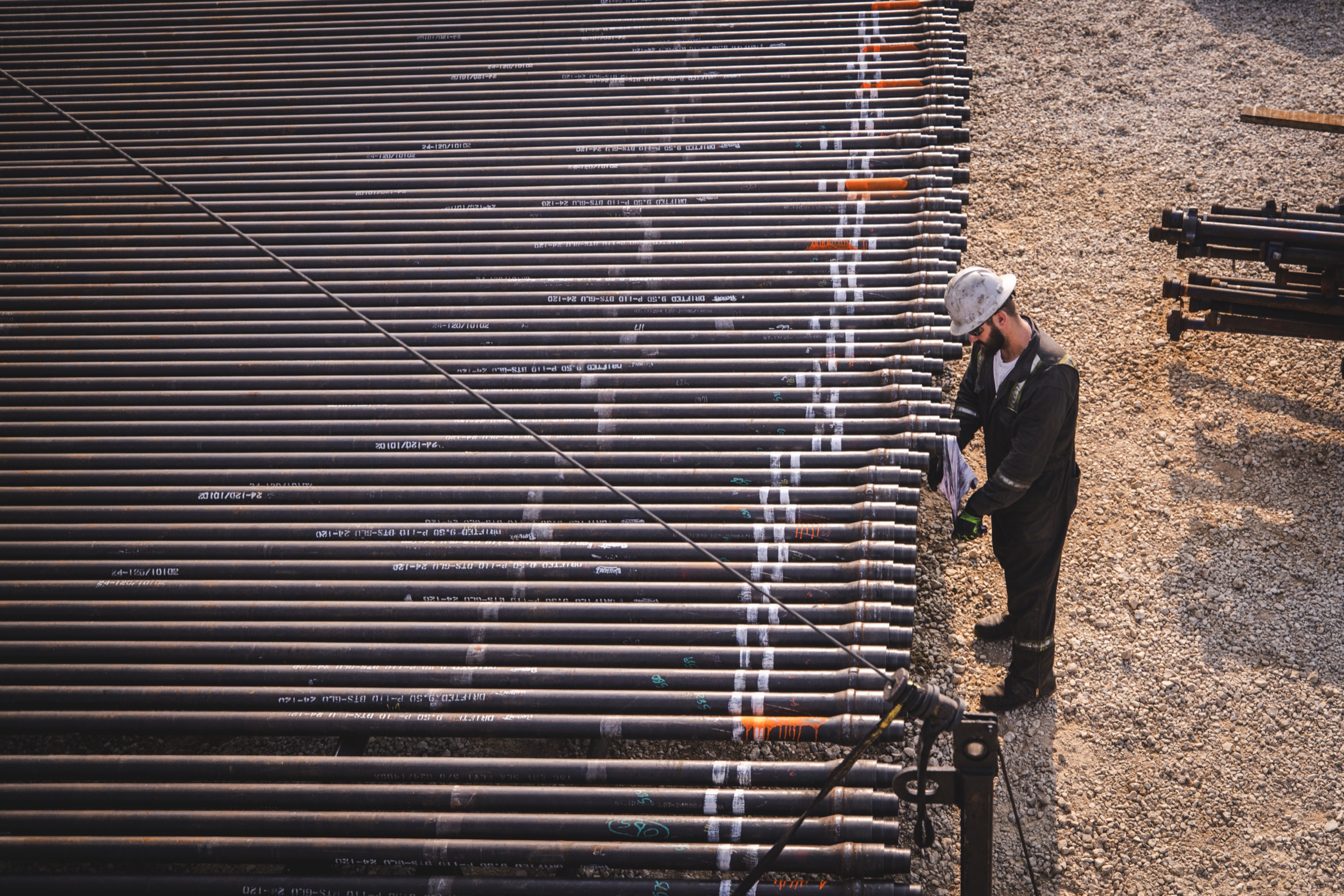 Crew member inspecting a rack of pipe